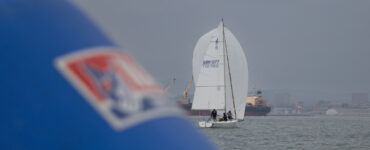 El J/80 Peninsula de John Bassadone navegando con spinnaker en aguas de La Línea durante el Circuito Alcaidesa Marina.